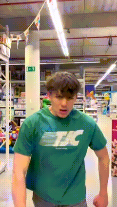 Young Man in Green T-Shirt Standing in Store