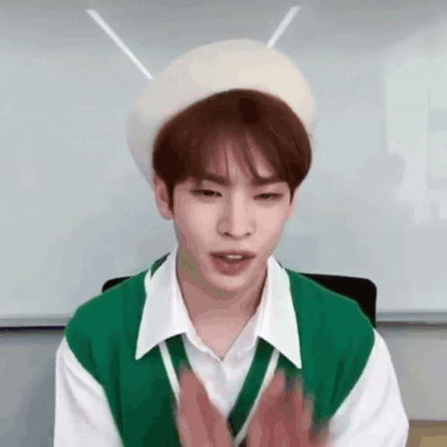 Young Man in Green Vest and White Beret Clapping