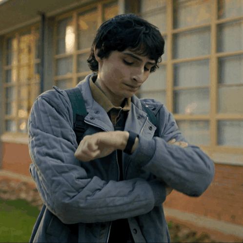 Young Man in Grey Jacket Looking at Watch