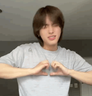 Young Man in Grey Shirt Making Heart With Hands