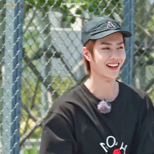 Young Man in Hat and Black Shirt Smiling
