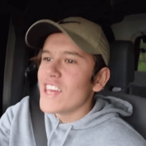 Young Man in Hat and Grey Hoodie Sitting in Car