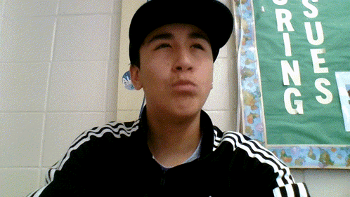 Young Man In Hat And Jacket At Rising Bulletin Board GIF