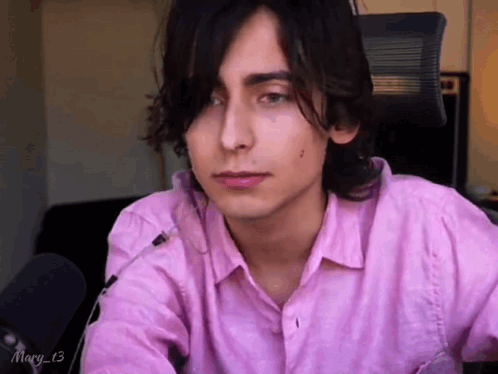 Young Man In Pink Shirt Sitting At Microphone GIF