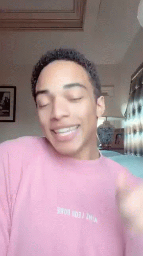 Young Man In Pink Sweater Smiling Making Funny Face GIF