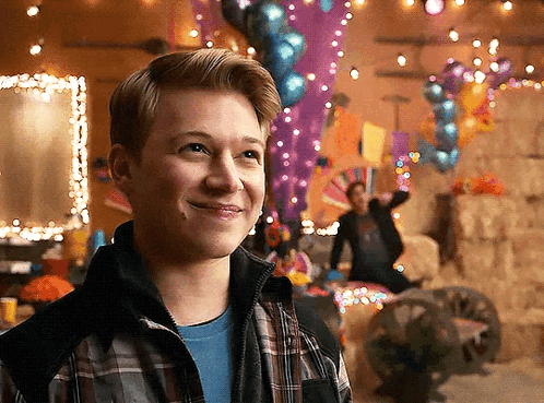 Young Man in Plaid Jacket Smiling With Balloons