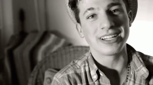 Young Man in Plaid Shirt and Hat Smiling