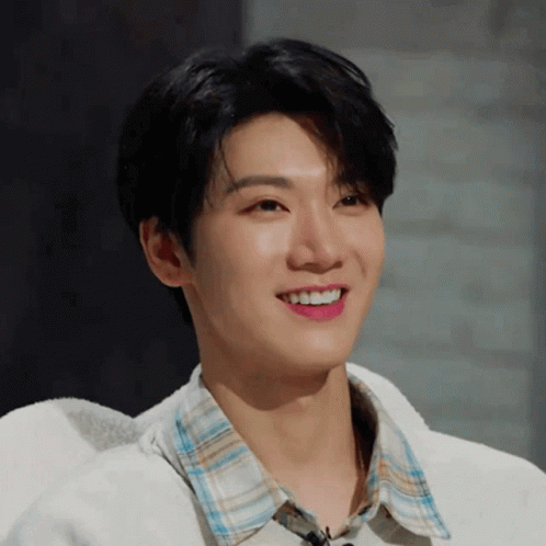 Young Man in Plaid Shirt and White Sweater Smiling