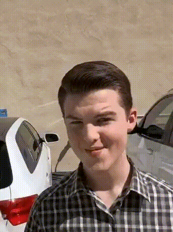 Young Man in Plaid Shirt in Front of White Car