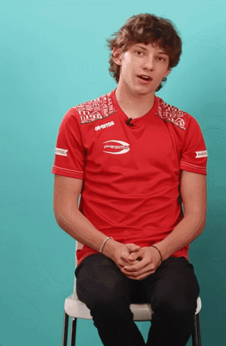 Young Man in Red Prestos Shirt Sitting