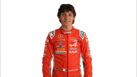 Young Man in Red Racing Suit Holding New Video Sign