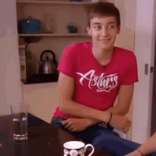 Young Man in Red Shirt with Coffee and Water