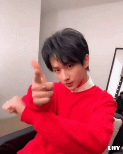 Young Man in Red Sweater Pointing at Camera