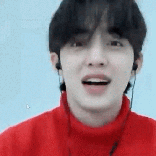 Young Man in Red Sweater With Earphones Smiling