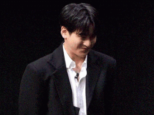 Young Man In Suit And Tie Holding Paper GIF