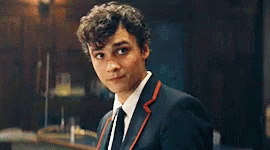 Young Man in Suit and Tie Looking at Camera in Dark Room