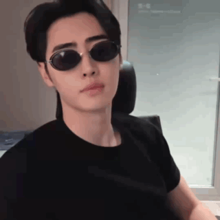 Young Man in Sunglasses and Black T-Shirt Sitting in Chair