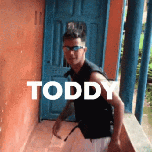 Young Man in Sunglasses by Blue Door With Toddy