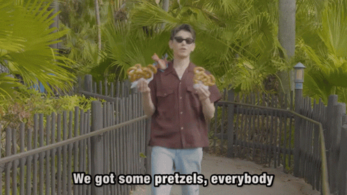 Young Man in Sunglasses Holding Pretzels Saying Got Some Pretzels