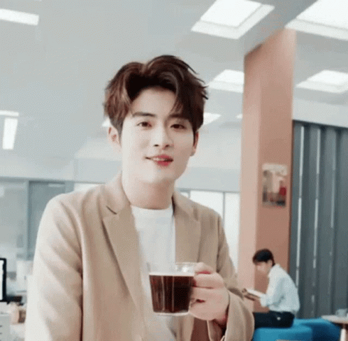 Young Man In Tan Jacket Holding Coffee GIF