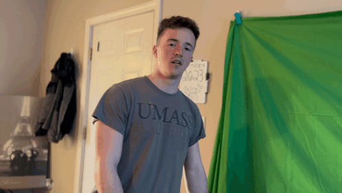 Young Man in UMass Shirt in Front of Green Screen