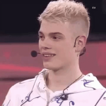 Young Man in White Hoodie Smiling with Microphone