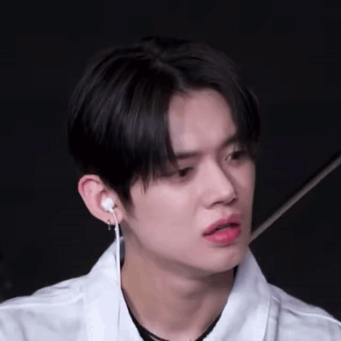 Young Man in White Shirt and Earbuds