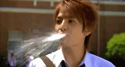 Young Man in White Shirt and Tie Drinking Water