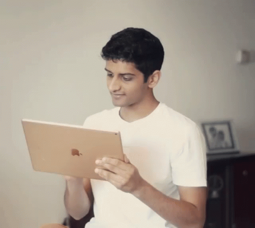 Young Man in White Shirt Holding Apple iPad