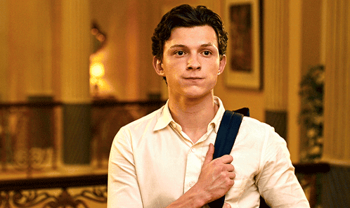 Young Man in White Shirt Holding Blue Bag