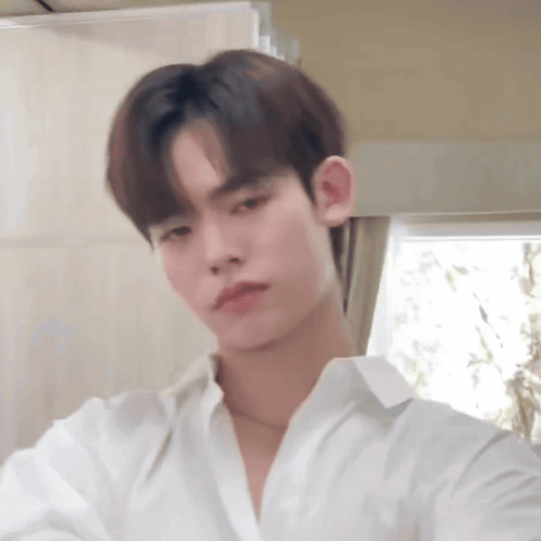 Young Man in White Shirt Looking at Camera