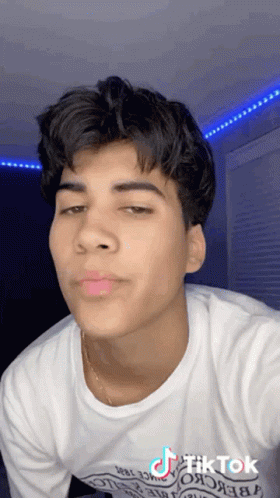 Young Man in White T-Shirt and Gold Chain Taking Selfie
