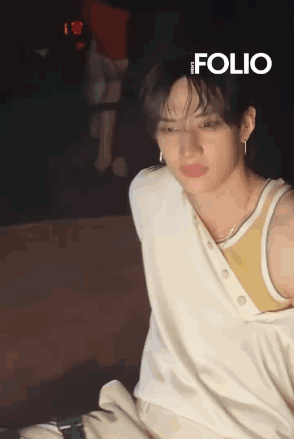 Young Man In White Tank Top And Earrings Sitting GIF
