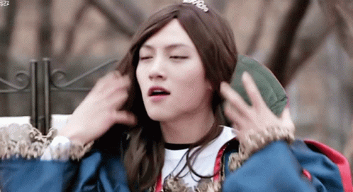Young Man In Wig And Crown Holding Green Bag GIF