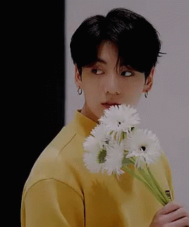 Young Man In Yellow Shirt Holding White Flowers GIF