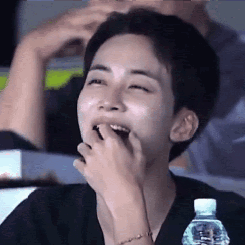 Young Man Laughing With Water Bottle in Stadium