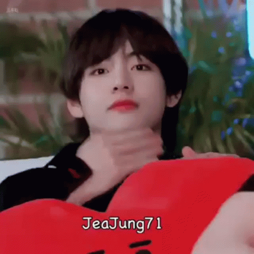 Young Man Laying On Couch Holding Red Pillow GIF