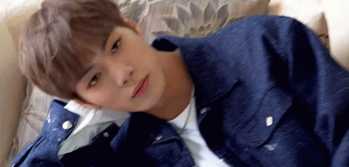 Young Man Laying On Couch In Denim Jacket GIF