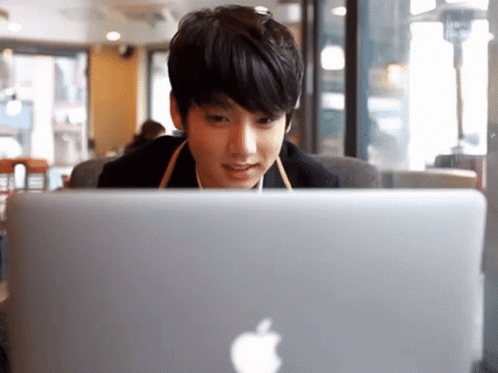 Young Man Looking at Apple Laptop