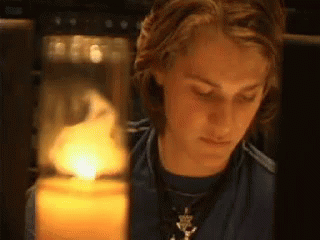 Young Man Looking at Lit Candle