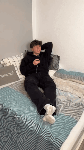 Young Man Lying on Bed with Menschen Pillow