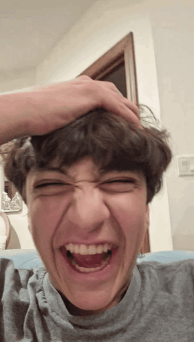 Young Man Making Funny Face With Hand On Head GIF