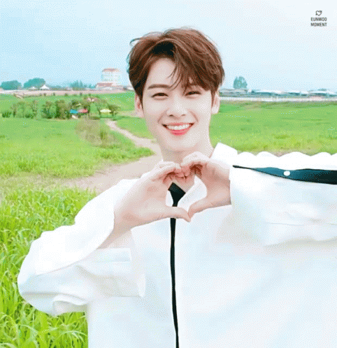 Young Man Making Heart With Hands in Field