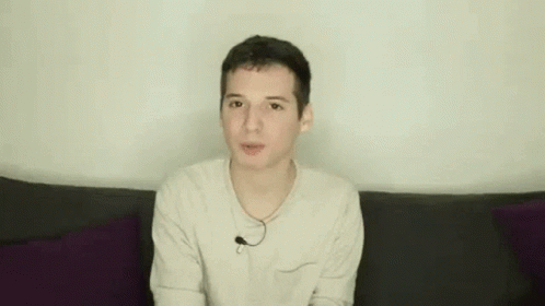 Young Man on Couch Making Funny Face Hands Up