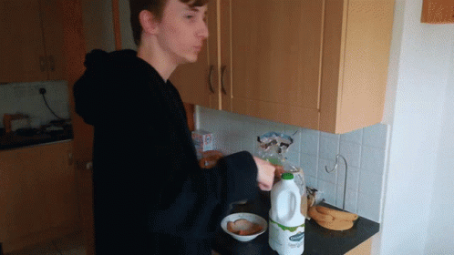Young Man Pouring Milk into Bowl