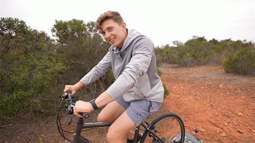 Young Man Riding Bike on Dirt Path