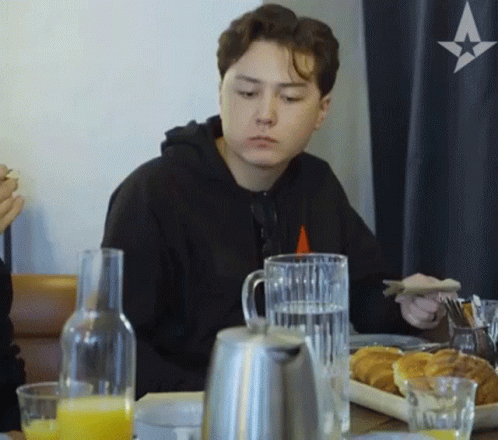 Young Man Sitting at Table with Plate of Food