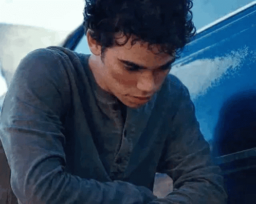 Young Man Sitting in Front of Blue Van