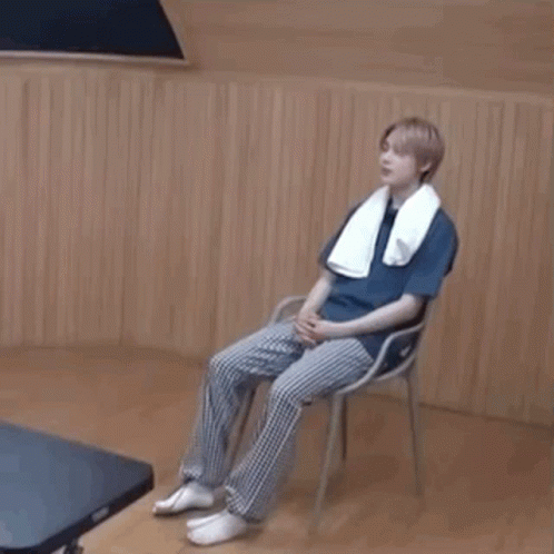 Young Man Sitting on Chair With Towel
