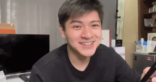 Young Man Smiling Holding Cell Phone